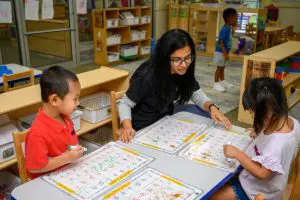 a child refining visual and tactile skills with Montessori cylinder blocks